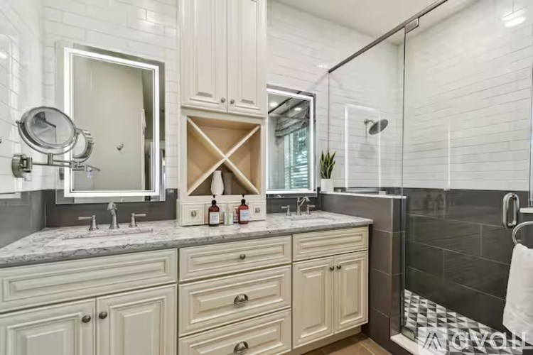A bathroom with a vanity, mirror, and shower.