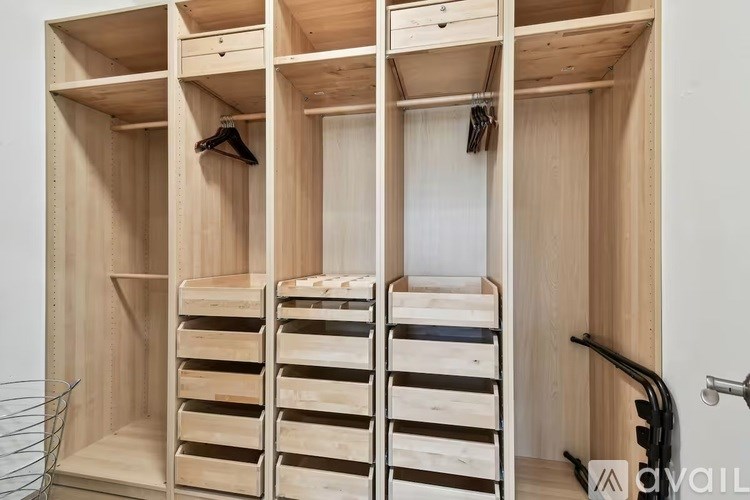 A wooden wardrobe with a mirror and hanging space.