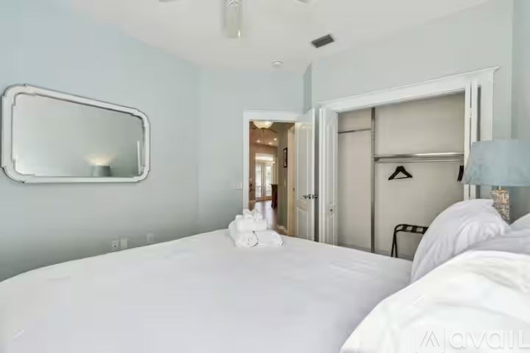 A bedroom with a large bed and a mirror on the wall.