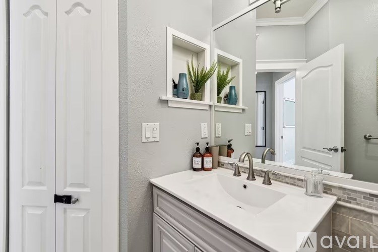 A bathroom with a white sink and a mirror above it.