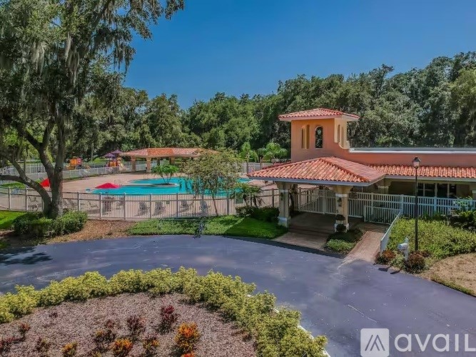 A house with a red roof and a pool in the backyard.
