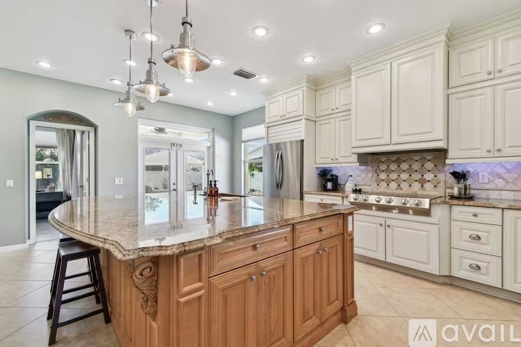 A kitchen with a large island and wooden cabinets.
