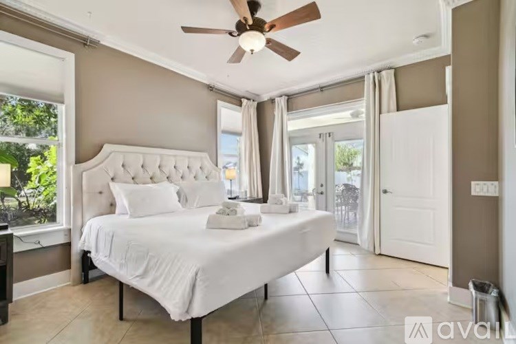 A bedroom with a large bed and a ceiling fan.