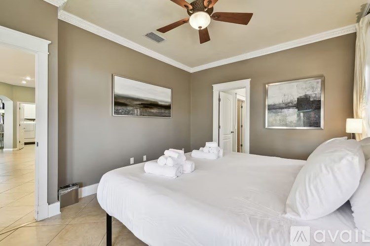A bedroom with a large bed and a ceiling fan.