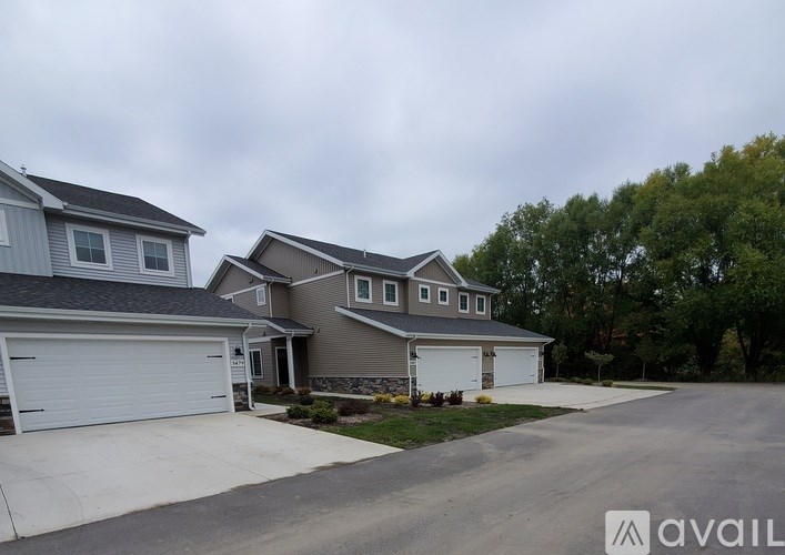 A house with a grey roof and a white garage door.