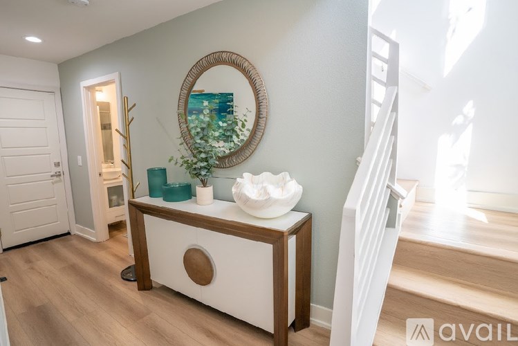 A bathroom with a round mirror and a white sink.