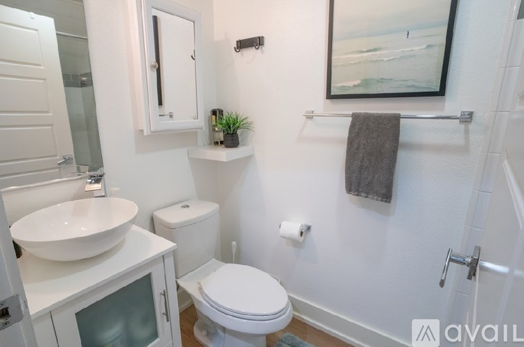 A white toilet sits next to a sink in a small bathroom.