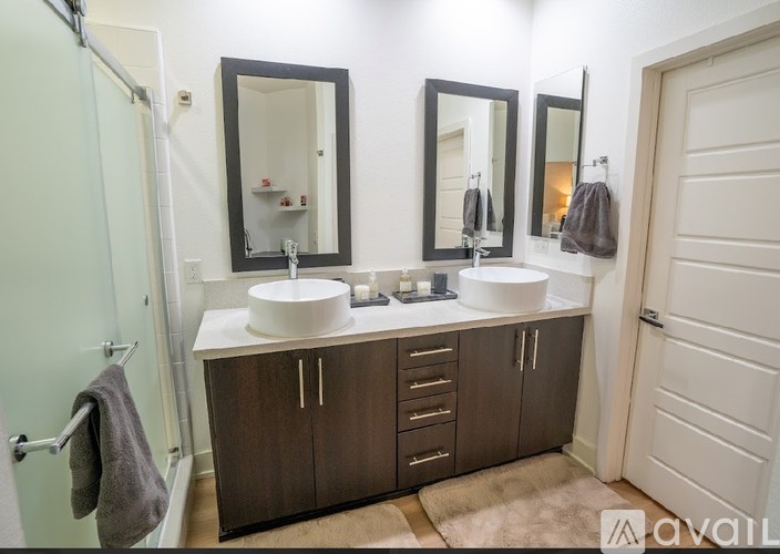 A bathroom with a sink, mirrors, and cabinets.
