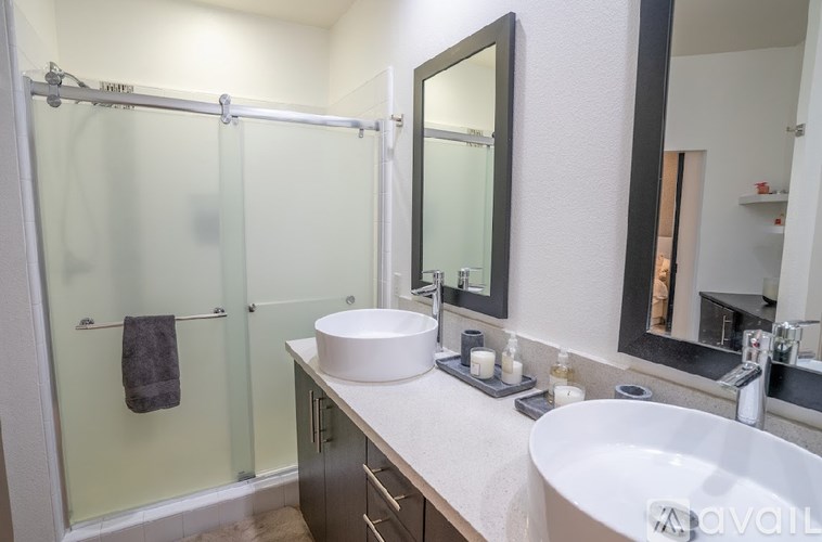 A bathroom with a white sink and a glass shower stall.