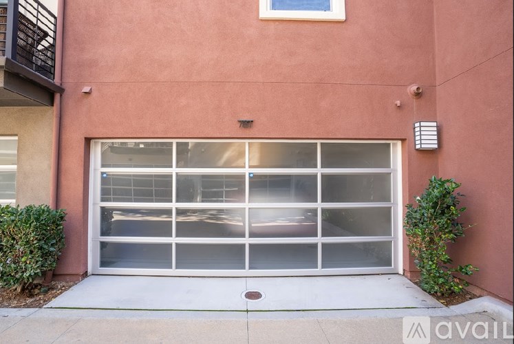 A garage door is closed and there is a small window above it.