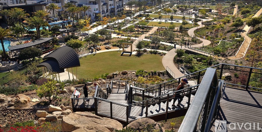 A view of a park with a bridge and a building in the background.