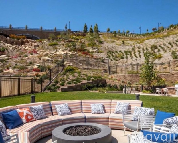 A patio with a striped couch and a fire pit.