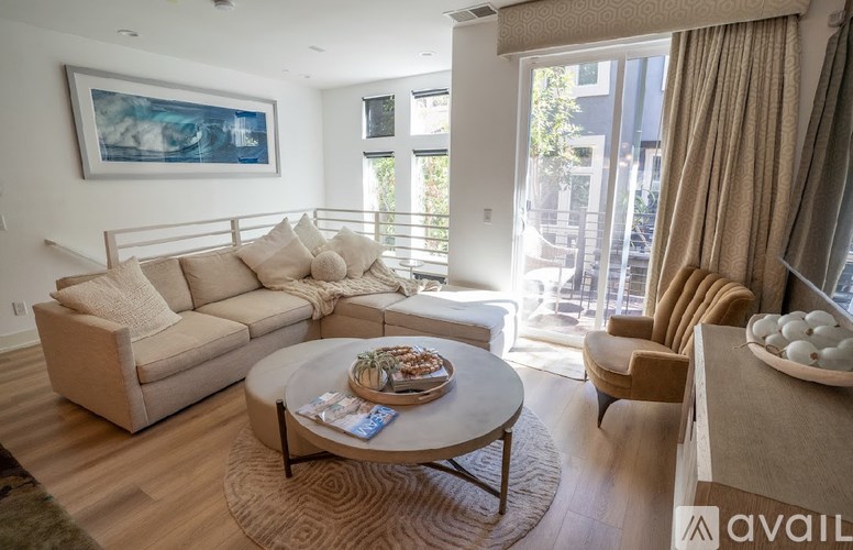 A living room with a white couch, a coffee table, and a painting on the wall.