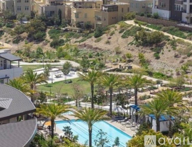 A pool surrounded by palm trees and buildings.
