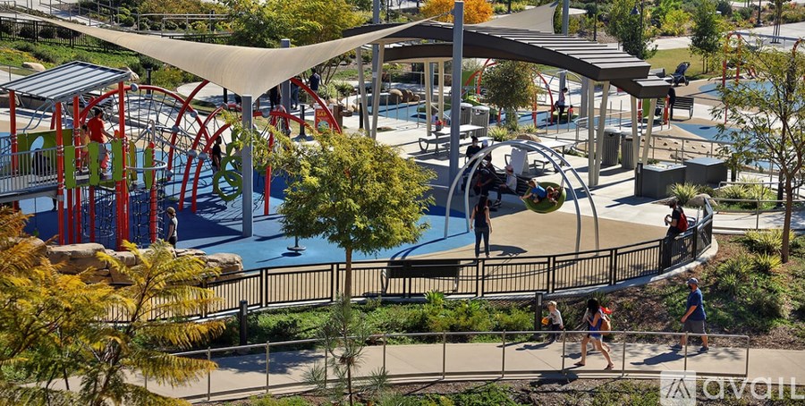 A playground with a red and blue slide and a white canopy.