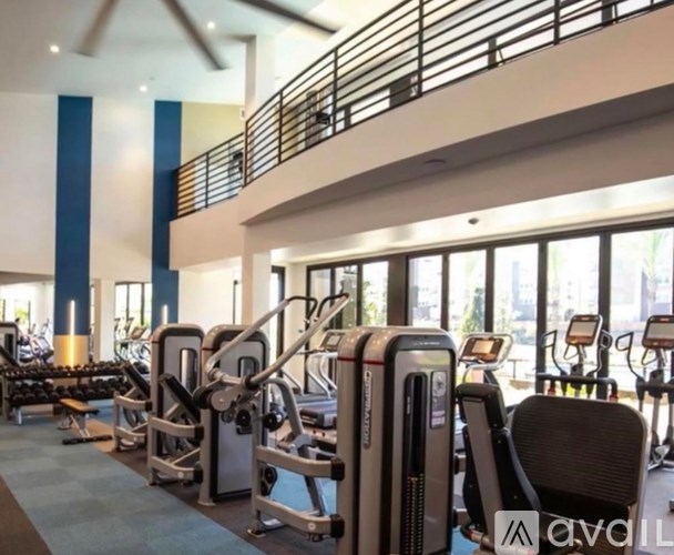 A gym with a variety of equipment including treadmills, weights, and exercise machines.