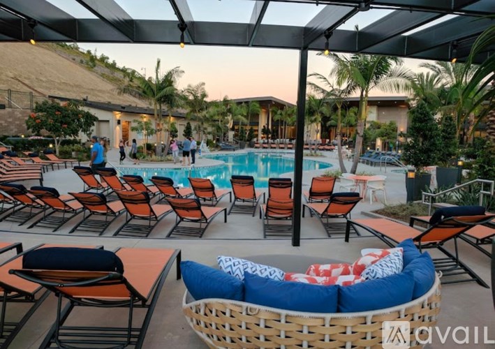 A poolside area with lounge chairs and a woven seating area.