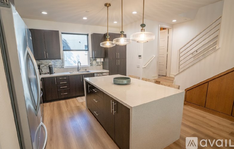 A kitchen with a white countertop and wooden cabinets.