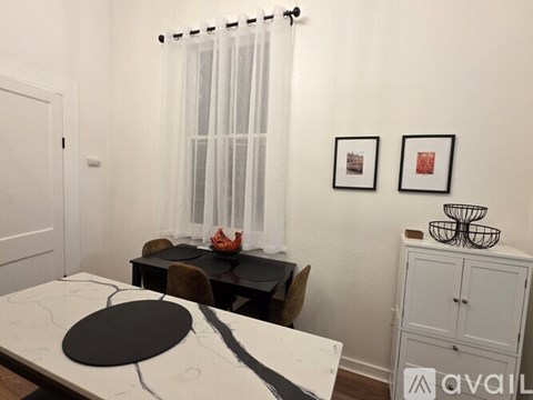 A dining room with a table and chairs.