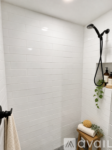 A white door with a black handle is open to a bathroom.