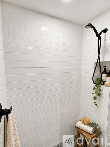 A white door with a black handle is open to a bathroom.