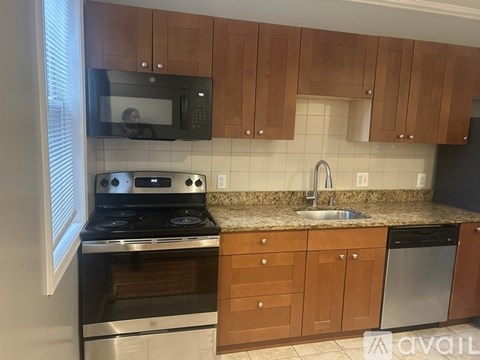 A kitchen with wooden cabinets and a black stove top oven.
