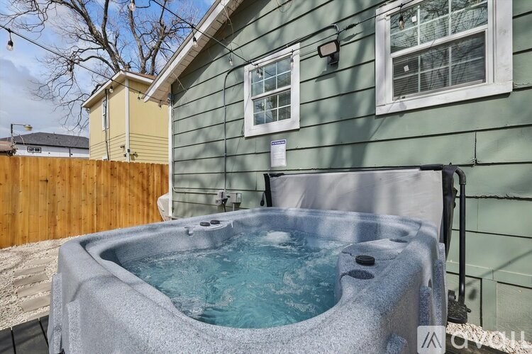 A hot tub sits in the middle of a yard.