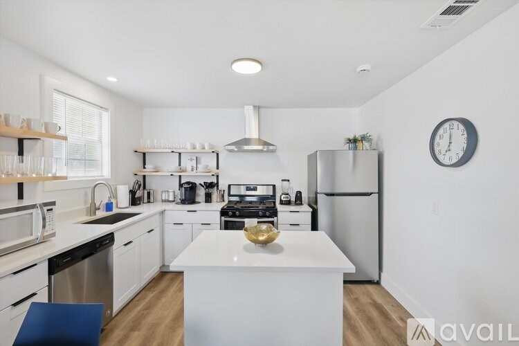 A modern kitchen with white appliances and a large island.
