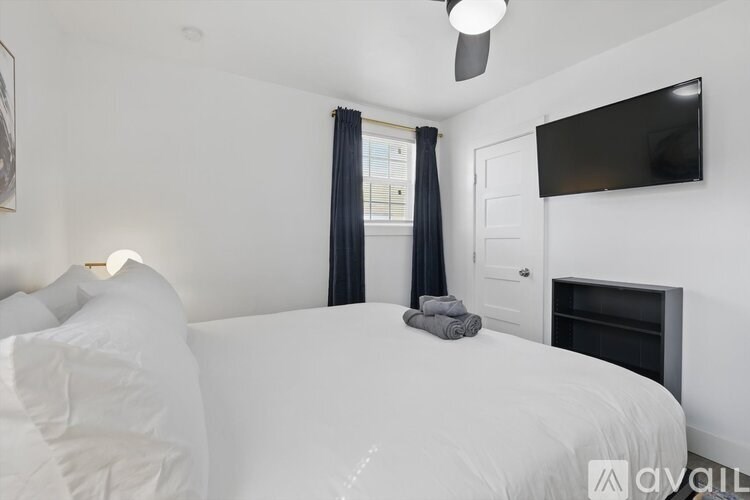 A bedroom with a bed, a television, and a fireplace.