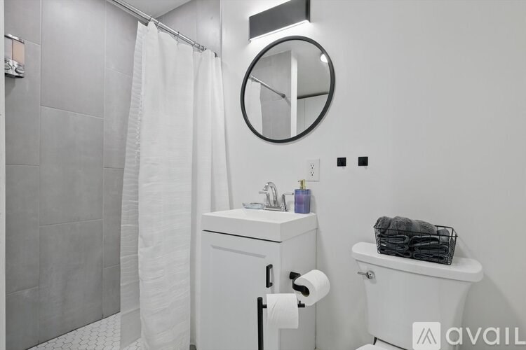 A bathroom with a white toilet, a white sink, and a white shower curtain.