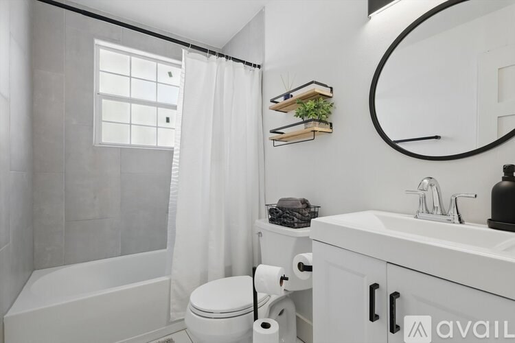 A bathroom with a white tub, toilet, and sink.