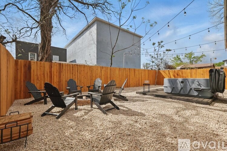 A backyard with a wooden fence and patio furniture.