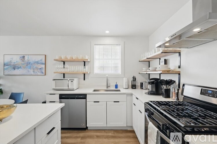 A modern kitchen with white cabinets and stainless steel appliances.