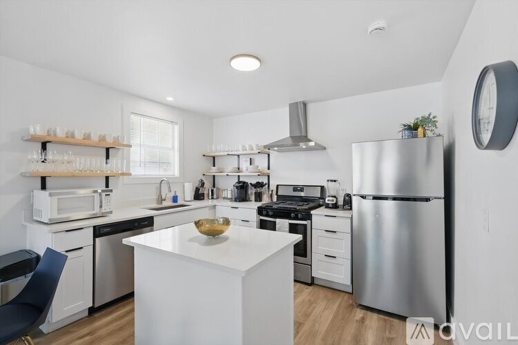 A modern kitchen with a white island and stainless steel appliances.