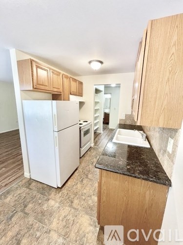 A kitchen with wooden cabinets and a white refrigerator.