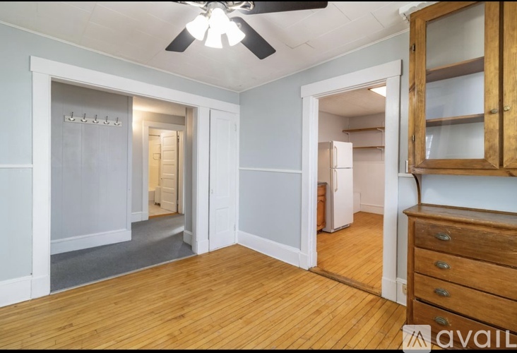 A room with wooden floors and a ceiling fan.