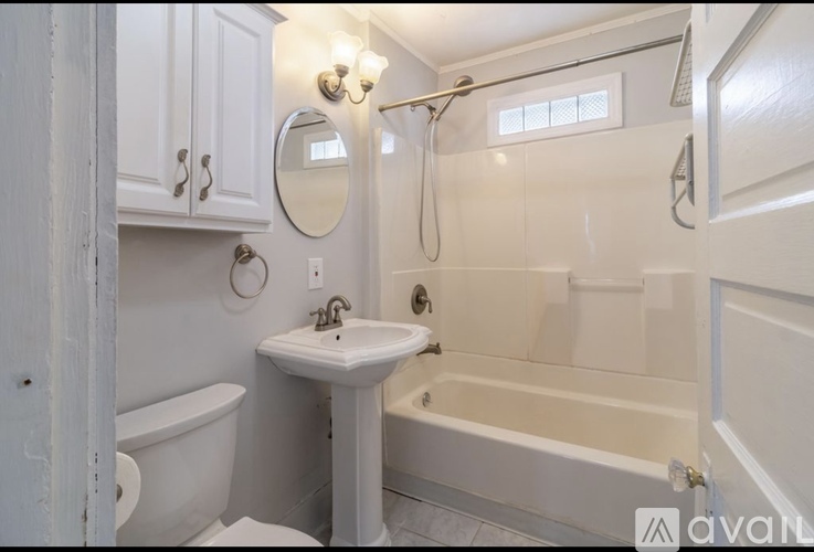 A white bathroom with a tub, sink, and toilet.