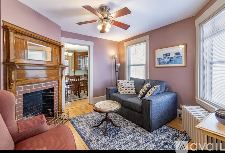 A living room with a fireplace and a blue couch.