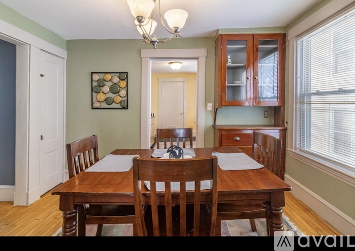 A dining room with a wooden table and chairs.