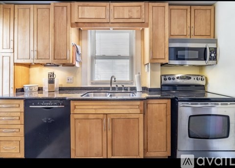 A kitchen with wooden cabinets and black appliances.