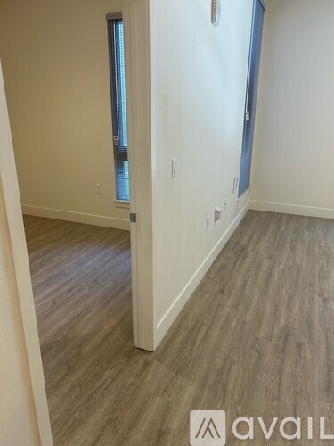 A room with wooden flooring and a window.