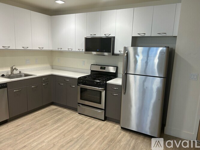 A kitchen with a refrigerator, oven, and microwave.