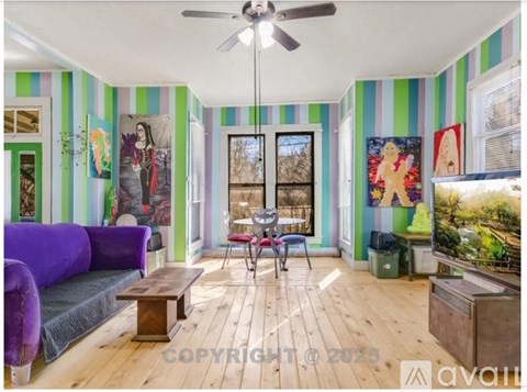 A living room with a purple couch and a wooden coffee table.