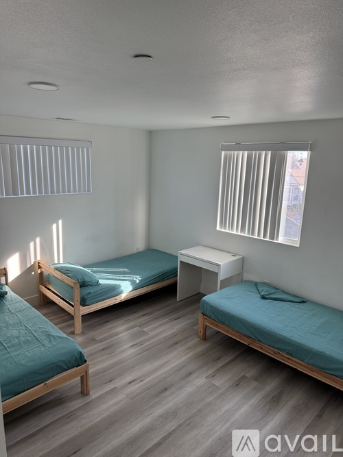 A bedroom with two beds and a nightstand.