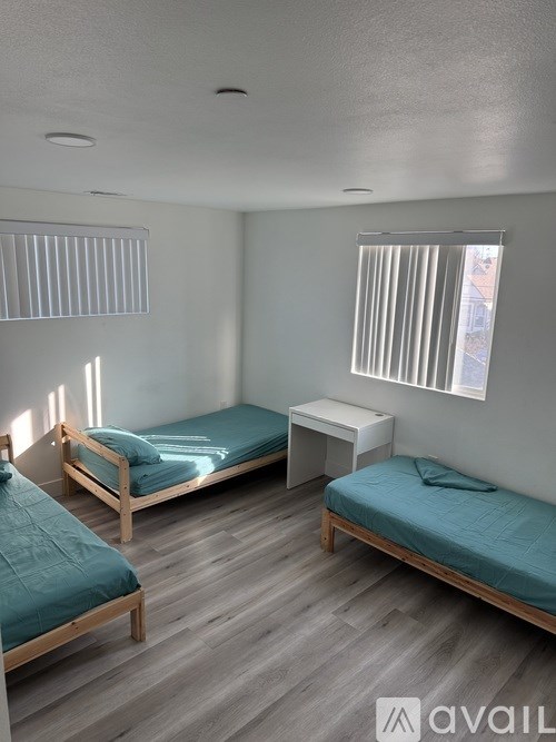 A bedroom with two beds and a nightstand.