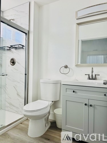 A white toilet sits next to a sink in a modern bathroom.