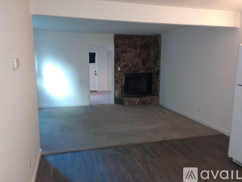 A living room with a fireplace and a rug on the floor.