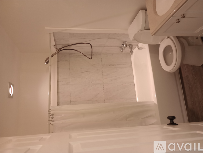 A bathroom with a toilet and a mirror above the sink.