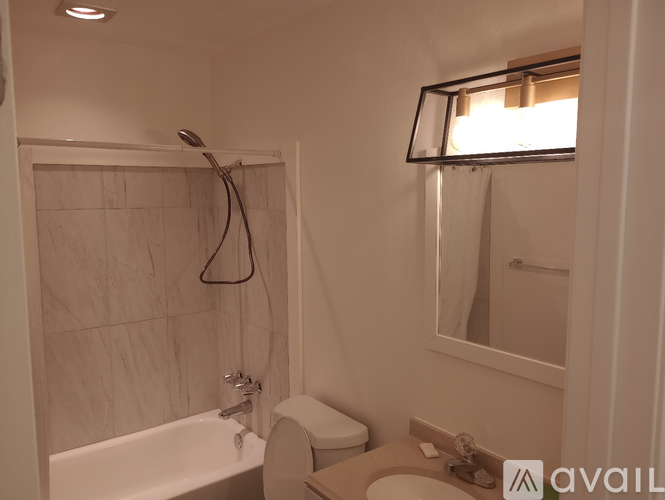 A bathroom with a tub, toilet, and sink.