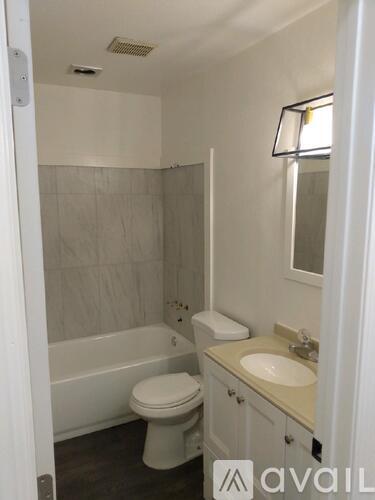 A bathroom with a toilet, sink, and bathtub.